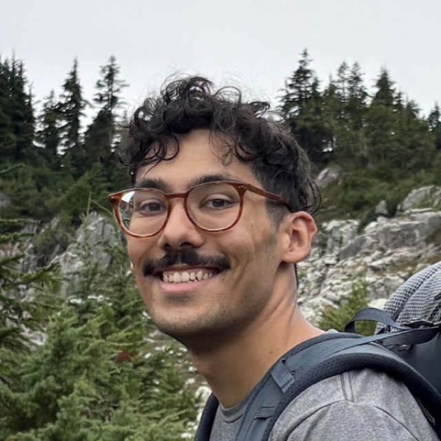 Pedro Zamora, smiling on a trail in the Cascades with a backpacking pack